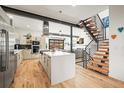 Open-concept kitchen features an island, stainless steel appliances, and seamless flow to the staircase at 536 S Vine St, Denver, CO 80209