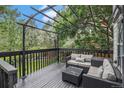 Relaxing back deck featuring comfortable seating, a pergola and mature trees at 11022 Trailrider Pass, Littleton, CO 80127