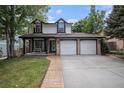 Charming two-story home with a well-manicured lawn and attached two car garage at 11022 Trailrider Pass, Littleton, CO 80127