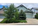 A light-green two-story house featuring well-kept landscaping, a lawn, and an attached two-car garage at 21734 Farmingdale Ct, Parker, CO 80138