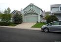 Home exterior with two-car garage and a car parked out front on a cloudy day in the neighborhood at 21734 Farmingdale Ct, Parker, CO 80138