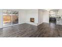 Bright living room with a cozy fireplace and sliding glass doors to the backyard at 8191 Tennyson St, Westminster, CO 80031