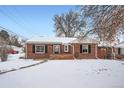 Ranch style brick home with a snow covered yard at 7505 Robinson Way, Arvada, CO 80003