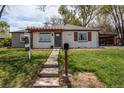 Attractive ranch-style home with white painted brick and a pergola covered porch at 6220 W 11Th Pl, Lakewood, CO 80214