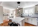Bright kitchen with white cabinets, stainless steel appliances, and a quartz island at 6220 W 11Th Pl, Lakewood, CO 80214