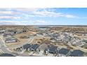 Expansive aerial view of the residential community with scenic lake backdrop on a sunny day at 7242 Canyon Sky Trl, Castle Pines, CO 80108