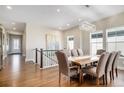 Bright dining room with wood floors, modern chandelier, and staircase leading to the second floor at 7242 Canyon Sky Trl, Castle Pines, CO 80108