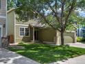 Exterior view of home featuring well-maintained lawn, mature tree, and attached two-car garage at 11082 Fillmore Way, Northglenn, CO 80233