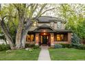 Charming two-story brick home with a large front yard and mature tree at 301 Fairfax St, Denver, CO 80220
