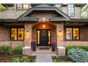 Inviting front entrance with brick archway, black door and colorful floral accents at 301 Fairfax St, Denver, CO 80220