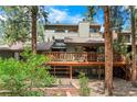 Backyard view features a wooden deck and surrounding greenery, offering a tranquil outdoor space at 4515 Red Rock Dr, Larkspur, CO 80118
