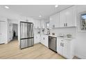 Modern white kitchen with stainless steel appliances and white subway tile backsplash at 1173 Xenon St, Golden, CO 80401