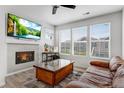 Bright living room featuring a cozy fireplace, TV, and large windows for natural light at 23743 E Ida Pl # E, Aurora, CO 80016