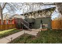 Home featuring a gray facade with brick accents, a small porch, and garden spaces at 3233 Meade St, Denver, CO 80211