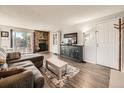 Living room featuring a stone fireplace, sliding glass door to the balcony, and wood-look flooring at 15911 E Dakota Pl # 301, Aurora, CO 80017