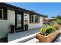 Inviting front entry with a modern door, stylish planters, and custom wood planter box at 6538 S Lee Ct, Centennial, CO 80121