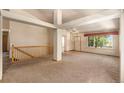 Bright living room featuring an open floor plan, high ceilings, a large window, and neutral carpet at 21444 E Lehigh Ave, Aurora, CO 80013