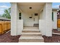 A welcoming front porch with white brick pillars, concrete steps, and a door with house numbers at 3346 W 33Rd Ave, Denver, CO 80211