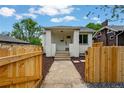 Charming home exterior with white brick, nice wood fence, landscaping and a sidewalk to the front door at 3346 W 33Rd Ave, Denver, CO 80211