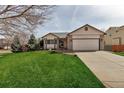 Inviting home exterior with manicured lawn, lush greenery, and an attached two-car garage at 2132 Boise Ct, Longmont, CO 80504