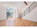 Open-concept living area with hardwood floors, lots of light, and modern staircase at 9948 King St, Westminster, CO 80031