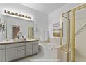 Bright bathroom featuring double vanity sinks, a tub, and a glass door shower at 13739 Legend Trl # 102, Broomfield, CO 80023