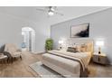 Bright bedroom features a ceiling fan, large bed, and a cozy seating area, with an ensuite bathroom in the background at 13739 Legend Trl # 102, Broomfield, CO 80023