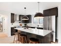 Modern kitchen with stainless steel appliances, an island with bar seating and unique pendant lighting at 4682 Chatham St, Boulder, CO 80301