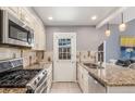 Galley kitchen features stainless appliances, granite countertops, and access to the home's backyard at 8360 W 87Th Dr # D, Arvada, CO 80005