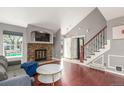 Sunlit living room features a decorative fireplace with TV nook and wood floors at 8360 W 87Th Dr # D, Arvada, CO 80005