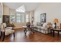 Inviting living room boasts hardwood floors, large windows with plantation shutters, and a comfortable seating arrangement at 16302 Parkside Dr, Parker, CO 80134