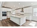 The spacious kitchen features white cabinets, stainless appliances, and a large island perfect for entertaining at 2596 Bailey Ln, Erie, CO 80026