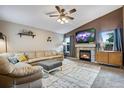 Inviting living room boasts a fireplace, neutral color palette, ceiling fan, and comfortable seating at 1179 S Alton Ct, Denver, CO 80247