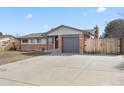 Single-story home with brick accents, a well-maintained lawn, and an attached garage with driveway at 2572 Beech Ct, Golden, CO 80401