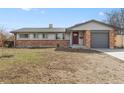 Charming single-story home with brick accents, a well-maintained lawn, and an attached garage at 2572 Beech Ct, Golden, CO 80401