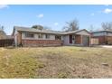 Single-story home with brick accents, a well-maintained lawn, and a driveway with walkway at 2572 Beech Ct, Golden, CO 80401