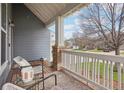 Inviting front porch with wooden deck, white railings, and comfortable seating arrangement at 10965 Dearborne Dr, Parker, CO 80134