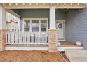 Cozy front porch with white railing, brick columns, and a seating area for relaxing at 10965 Dearborne Dr, Parker, CO 80134
