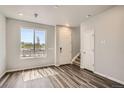 Bright entryway features wood-look flooring, neutral paint, a window, and a white front door at 6827 Huddersfield Ln, Castle Pines, CO 80108