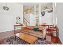 Spacious living room featuring soaring ceilings, hardwood floors, and an open layout with stairs at 10115 Cook St, Thornton, CO 80229