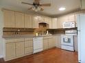 Bright kitchen features wood floors, white appliances, and stylish mosaic tile backsplash at 9625 E Center Ave # 4C, Denver, CO 80247