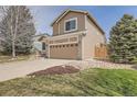View of a two-story home, showcasing the garage and landscaped front yard at 19131 E Crestridge Cir, Aurora, CO 80015