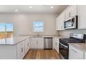 Modern kitchen featuring white cabinets, stainless steel appliances, and a bright window view at 48295 Shetland Dr, Bennett, CO 80102