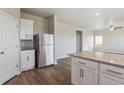 Open-concept kitchen with a stainless steel refrigerator and a center island at 48295 Shetland Dr, Bennett, CO 80102