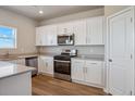 Bright kitchen with white cabinetry, stainless steel appliances, and a light countertop at 48295 Shetland Dr, Bennett, CO 80102