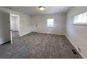 Spacious living room with natural light, carpet floors, and an open layout to adjacent rooms at 2429 S Cherokee St, Denver, CO 80223