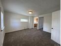 A brightly lit living room with fresh carpet, white walls and modern recessed lighting at 2429 S Cherokee St, Denver, CO 80223