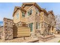 Beautiful multi-story townhouse featuring stone accents, large windows, and a well-manicured yard at 5722 S Addison Way # A, Aurora, CO 80016