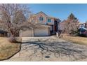 Two-story home with a three-car garage, long driveway and a well-maintained front lawn at 9554 E Hidden Hill Ln, Lone Tree, CO 80124