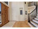 Inviting foyer featuring hardwood floors, a staircase with iron railing and a view to the front door at 9554 E Hidden Hill Ln, Lone Tree, CO 80124